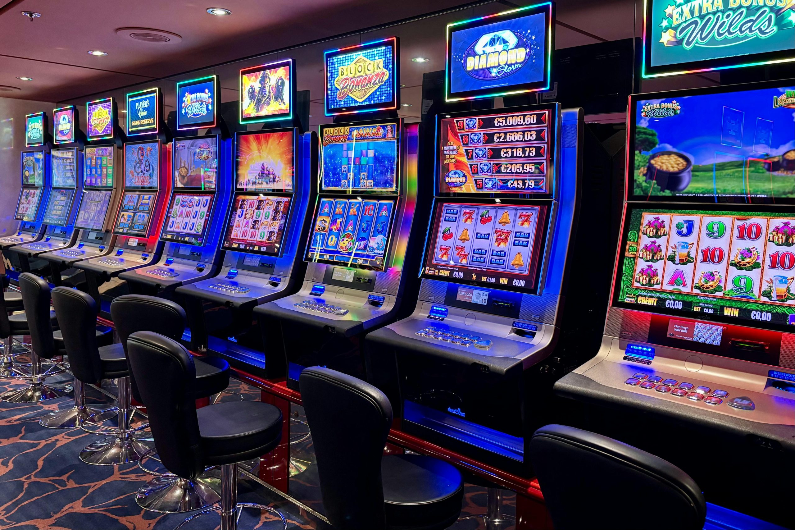 Bright casino slot machines with colorful displays and no people present.